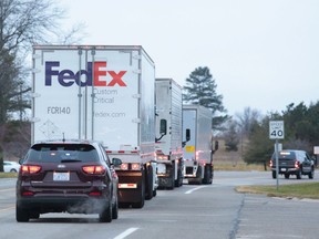 A FedEx truck leaves the Pfizer Global Supply manufacturing plant with a small convoy, amid the COVID-19 outbreak, in Portage, Mich., Dec. 13, 2020.