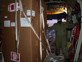 Special freezers for COVID-19 vaccines are unloaded by MCpl Julien Simard members of the Royal Canadian Air Force’s 436 Transport Squadron in support of the Public Health Agency of Canada from a transport aircraft in an unidentified northern territory, Canada Dec. 12, 2020.