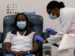 Sandra Lindsay,  a nurse at Long Island Jewish Medical Center, is inoculated with the COVID-19 vaccine by Dr. Michelle Chester from Northwell Health at Long Island Jewish Medical Center in New Hyde Park, N.Y., Dec. 14, 2020.