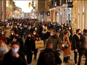 People walk along Via Del Corso street as the government prepares further restrictions over the Christmas period in an attempt to curb the spread of COVID-19 in Rome, Italy Dec. 19, 2020.