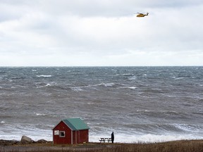 An RCAF Cormorant helicopter flies over the Bay of Fundy in Hillsburn, N.S. in an area where empty life-rafts from a scallop fishing vessel where reported on Tuesday, Dec. 15, 2020.