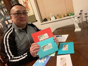 Louis Huang is pictured with Christmas cards he's written, addressed to Michael Kovrig and Michael Spavor, both currently being held in Chinese prisons overseas.