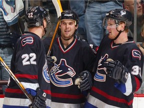 Jason King, who once drew notice as a winger for the Sedin twins leading to the trio being dubbed the Mattress Line — two twins and a king — has been promoted from the Utica Comets to serve as an assistant coach to Canucks head coach Travis Green. In this photo, Daniel Sedin #22 and twin brother Henrik #33 of the Vancouver Canucks congratulate teammate Jason King #17 after he scored a goal against the Minnesota Wild during the first period of their NHL game at General Motors Place November 8, 2003 in Vancouver, Canada.