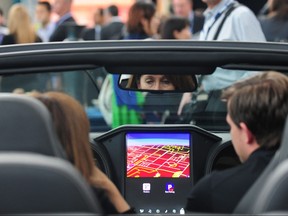 In this file photo people seated in a Bentley discuss the QNX Technology options on the large display screen on Nov. 19, 2013 in Los Angeles, where the LA Auto Show opened for a media preview three days before opening to the public.