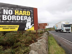 In this file photo taken on Oct. 1, 2019 a freight lorry passes an anti-Brexit pro-Irish unity billboard, pictured from the Dublin road in Newry, on the border between Newry in Northern Ireland and Dundalk in the Irish Republic.