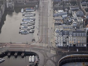 This aerial picture taken on December 20, 2020, shows tour boats at an empty station square and Damrak Square in Amsterdam.