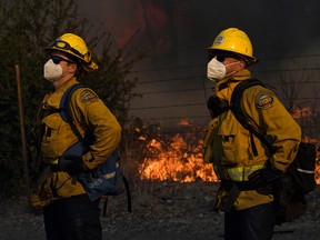 Orange County Fire Authority (OCFA) firefighters wear masks while working to contain the Bond Fire near Lake Forest, California, December 3, 2020.