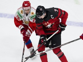 Canada's Kirby Dach (7) battles for the puck with Russia's Marat Khusnutdinov (22) during second period IIHF World Junior Hockey Championship exhibition action on Wednesday, Dec. 23, 2020 in Edmonton.