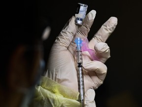 A pharmacist technician fills the Pfizer-BioNTech COVID-19 mRNA vaccine at a vaccine clinic during the COVID-19 pandemic in Toronto on Tuesday, Dec. 15, 2020.