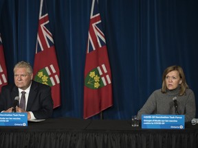 Deputy Premier and Minister of Health Christine Elliott responds to a question as Ontario Premier Doug Ford listens during a press conference at Queen's Park in Toronto on Friday, December 11, 2020.