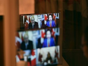 Canadian Prime Minister Justin Trudeau and UK Prime Minister Boris Johnson are seen in a pre-recorded video during a news conference in Ottawa, Saturday, Nov. 21, 2020.