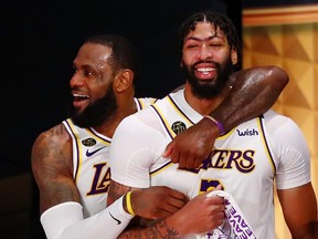 Los Angeles Lakers forward LeBron James, left, and forward Anthony Davis celebrate during the fourth quarter in Game 6 of the 2020 NBA Finals at AdventHealth Arena in Lake Buena Vista, Florida, Oct. 11, 2020.