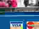 Visa and MasterCard credit card logos are seen in a store window in Washington on March 30, 2012. 