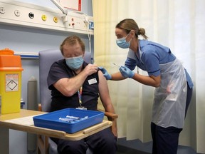 Deputy charge nurse Katie McIntosh administers the first of two Pfizer/BioNTech COVID-19 vaccine jabs, to Clinical Lead of Outpatient Theatres Andrew Mencnarowski, at the Western General Hospital, on the first day of the largest immunisation programme in the British history, in Edinburgh, Scotland Britain December 8, 2020.