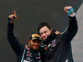 Mercedes' Lewis Hamilton celebrates on the podium with team principle Toto Wolff after winning the race and the world championship.