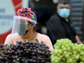 A woman selling fruits wears a face shield during a health campaign by the Ministry of Health (MINSA), to distribute some 2,000 face screens as a measure to reduce the spread of COVID-19, in Panama City on Dec. 14, 2020.