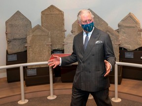 Britain's Prince Charles, seen wearing a protective face covering to combat the spread of the coronavirus, gestures during a visit to the Corinium Museum in Cirencester, England, Friday, Dec. 18, 2020.