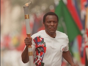 Olympic decathalete Rafer Johnson of the USA carries the Olympic torch on the first leg of the cross country relay from the Los Angeles Memorial Coliseum in Los Angeles, California to Atlanta, Ga., April 27, 1996.