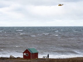 An RCAF Cormorant helicopter flies over the Bay of Fundy in Hillsburn, N.S. in an area where empty life-rafts from a scallop fishing vessel where reported on Tuesday, Dec. 15, 2020.