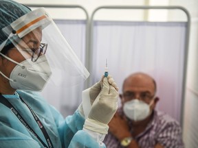 A health worker prepares a syringe to inoculate a volunteer with a COVID-19 vaccine produced by the Chinese Sinopharm during its trial at the Clinical Studies Center of the Cayetano Heredia University in Lima on Dec. 9, 2020.