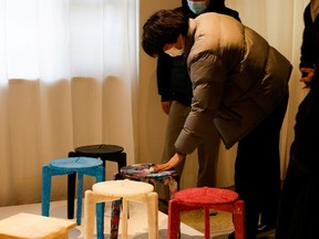 A university student touches an upcycled stool made from discarded protective masks by Kim Ha-neul who is majoring in furniture design, on display at a graduation exhibition in Uiwang, South Korea, Dec. 7, 2020.