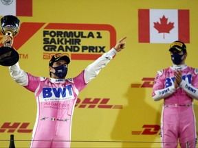 Race winner Sergio Perez of Mexico and Racing Point celebrates his maiden F1 victory on the podium while Canadian driver Lance Stroll looks on during the F1 Grand Prix of Sakhir at Bahrain International Circuit, Sunday, Dec. 6, 2020, in Bahrain.
