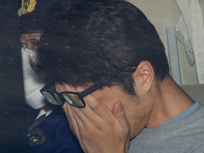 Takahiro Shiraishi covers his face inside a police car in Tokyo, in this photo taken by Kyodo in November 2017 and released by Kyodo on Tuesday, Dec. 15, 2020.