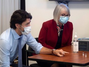 Prime Minister Justin Trudeau and Minister of Health Patty Hajdu look at empty vials which held the Pfizer-BioNTech COVID-19 vaccine during a visit to the Civic Hospital in Ottawa, Tuesday, Dec. 15, 2020.