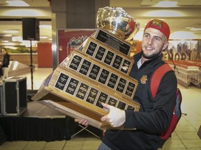 University of Calgary Dinos quarterback Adam Sinagra carries the Vanier Cup at the team's arrival in Calgary on Nov. 24, 2019. The Dinos defeated the Montreal Carabins the day before in the Vanier Cup game.