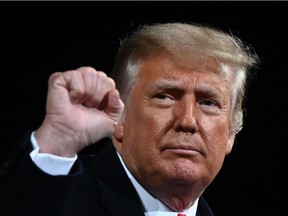 In this file photo US President Donald Trump raises his fist at the end of a rally to support Republican Senate candidates at Valdosta Regional Airport in Valdosta, Georgia on December 5, 2020.