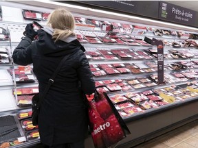 A customer shops at a meat counter in a grocery store in Montreal, on Thursday, April 30, 2020.