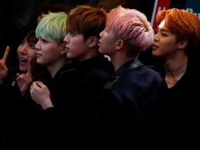 Members of South Korean K-Pop band BTS react on the red carpet during 2015 Mnet Asian Music Awards (MAMA) in Hong Kong, China, December 2, 2015.