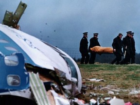 File photo from December 22, 1988 shows rescue personnel carrying a body away from the site of the crash in Lockerbie.