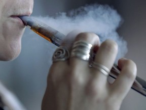 A woman uses an electronic cigarette in Mayfield Heights, Ohio on Friday, Oct. 4, 2019.