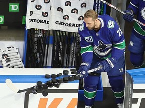 EDMONTON, ALBERTA - AUGUST 29: Alexander Edler #23 of the Vancouver Canucks knocks pucks off the boards prior to his game against the Vegas Golden Knights in Game Three of the Western Conference Second Round during the 2020 NHL Stanley Cup Playoffs at Rogers Place on August 29, 2020 in Edmonton, Alberta, Canada.