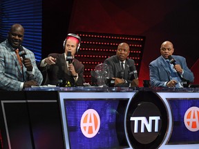 TNT's Inside the NBA team (L-R) NBA analyst Shaquille O'Neal, host Ernie Johnson Jr., wearing an iGrow laser-based hair-growth helmet, and NBA analysts Kenny Smith and Charles Barkley.