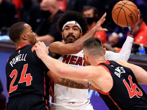 Miami Heat's Gabe Vincent is pressured by Raptors' Norman Powell and Aron Baynes during Friday's game.