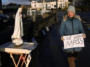 A Catholic worshipper protests with prayer by doing a rosary rally for the return of public Mass, after the government imposed the highest level of restrictions amid the spread of the coronavirus, in Galway, Ireland, Friday, Jan. 1, 2021.