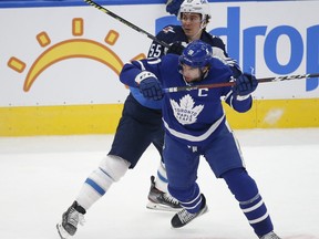 Jets' Mark Scheifele checks Maple Leafs' John Tavares during the first period in Toronto on Monday.