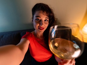 Woman Holding Glass of Wine, Smiling and Making Selfie For Friends or Relatives. Online Cheers, Meeting in Social Distancing And Isolation. Communication in Time of Quarantine