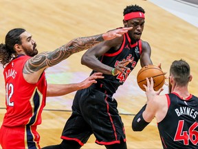 Raptors’ Pascal Siakam (centre) passes to teammate Aron Baynes as Pelicans’ Steven Adams defends on Saturday night in New Orleans.