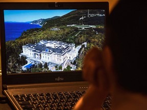 A woman watches an investigation film by Russian opposition leader Alexei Navalny showing a property, located along Russia's southern Black Sea, that Navalny claims is owned by Russian President Vladimir Putin, on January 25, 2021 in Moscow.