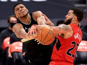 Giannis Antetokounmpo (left) of the Bucks and Fred VanVleet of the Toronto Raptors fight for the ball on Wednesday night at Amalie Arena.