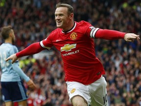 In this file photo taken Sept. 27, 2014, Manchester United striker Wayne Rooney celebrates scoring the opening goal during a English Premier League match between Manchester United and West Ham United at Old Trafford in Manchester.