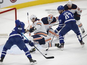Leafs forward Pierre Engvall, right, fights for the puck in front of the net as the Leafs beat the Oilers. Jack Boland/Toronto Sun/Postmedia Network