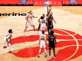 Aron Baynes #46 of the Toronto Raptors and Bam Adebayo #13 of the Miami Heat jump ball during a game at Amalie Arena on January 22, 2021 in Tampa, Florida.