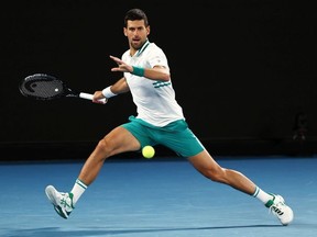 Novak Djokovic of Serbia plays a forehand in his Men's Singles fourth round match against Milos Raonic of Canada during day seven of the 2021 Australian Open at Melbourne Park on February 14, 2021 in Melbourne, Australia.