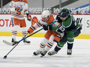 Vancouver Canucks forward Bo Horvat (53) checks Edmonton Oilers forward Dominik Kahun (21) in the first period at Rogers Arena on Feb. 23, 2021.
