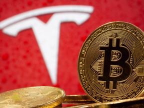 Representations of virtual currency Bitcoin are seen in front of Tesla logo in this illustration taken, Feb. 9, 2021.