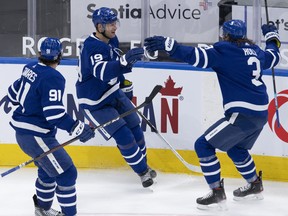 Maple Leafs centre Jason Spezza (19) is congratulated on his third goal of the game by teammates John Tavares (91) and Justin Holl (3) during the third period against the Vancouver Canucks in Toronto on Thursday, Feb. 4, 2021.